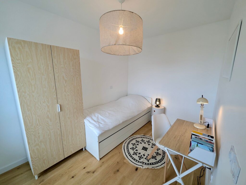 Chambre enfant avec des tons naturels comprenant un lit banquette, une penderie et un bureau