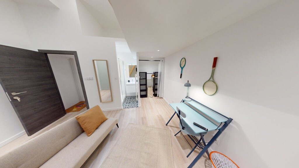 Grande chambre toute équipée avec un petit espace salon sur le thème du sport dans une colocation
