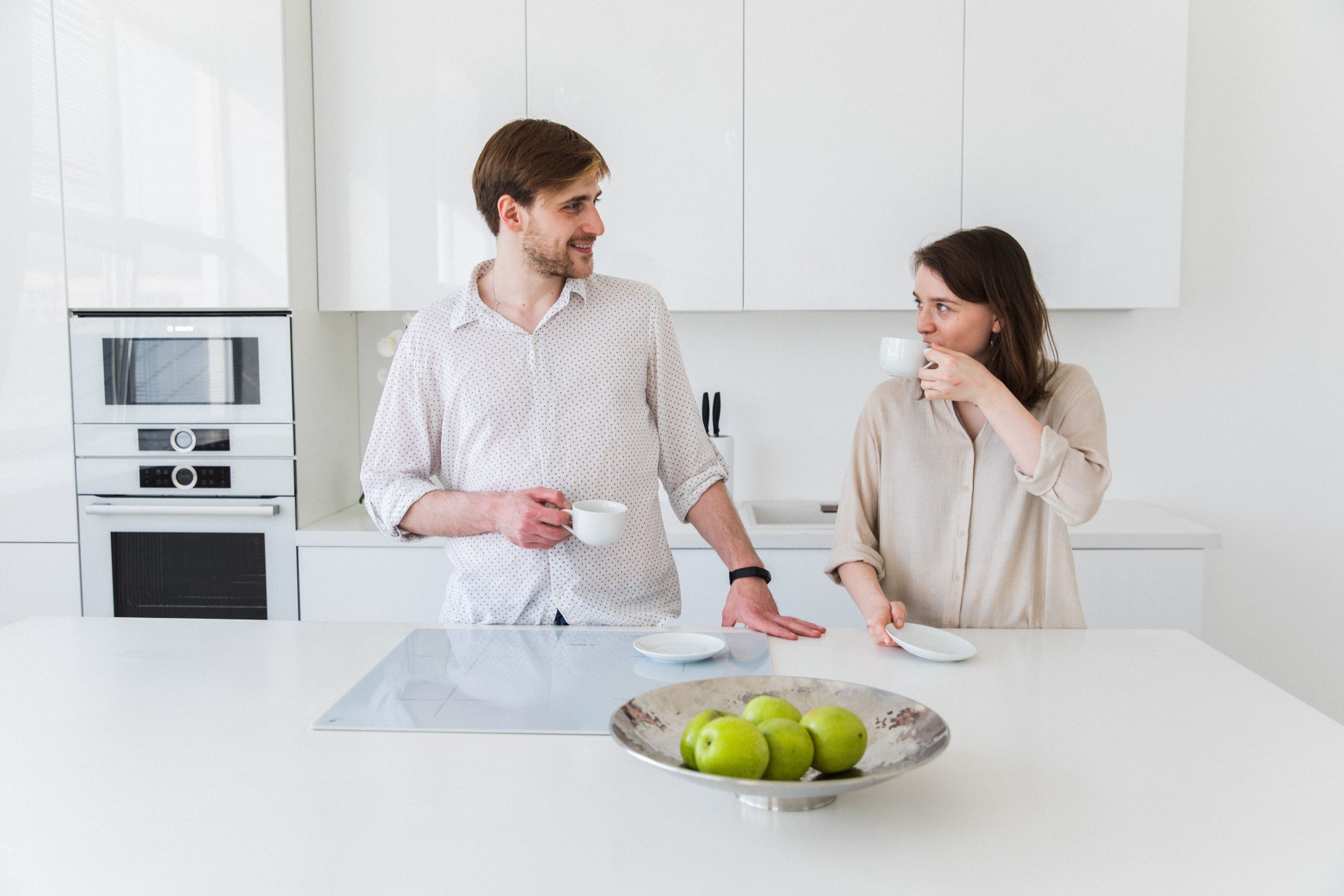 Couple prenant un café dans une cuisine blanche moderne