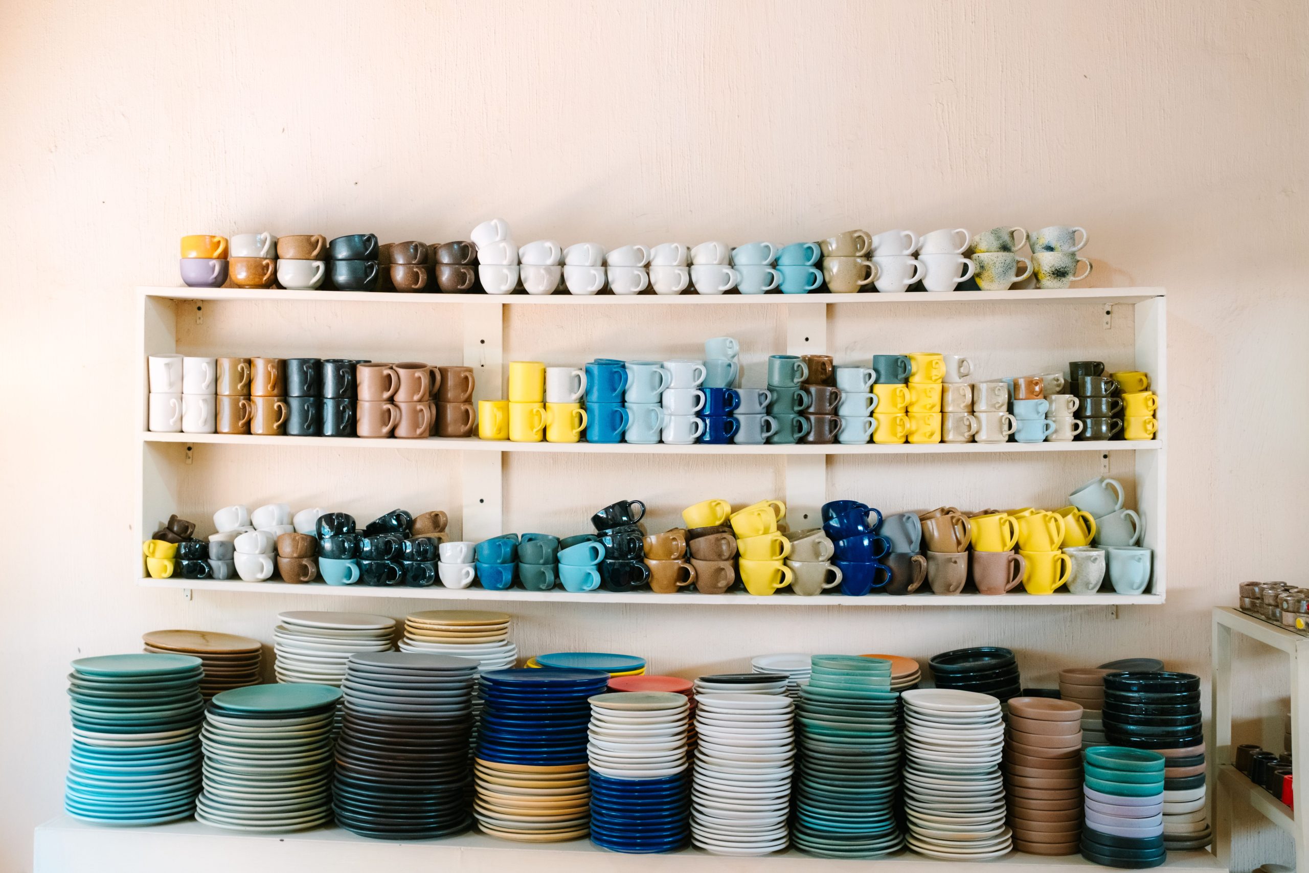 Mugs colorés et assiettes sur étagères