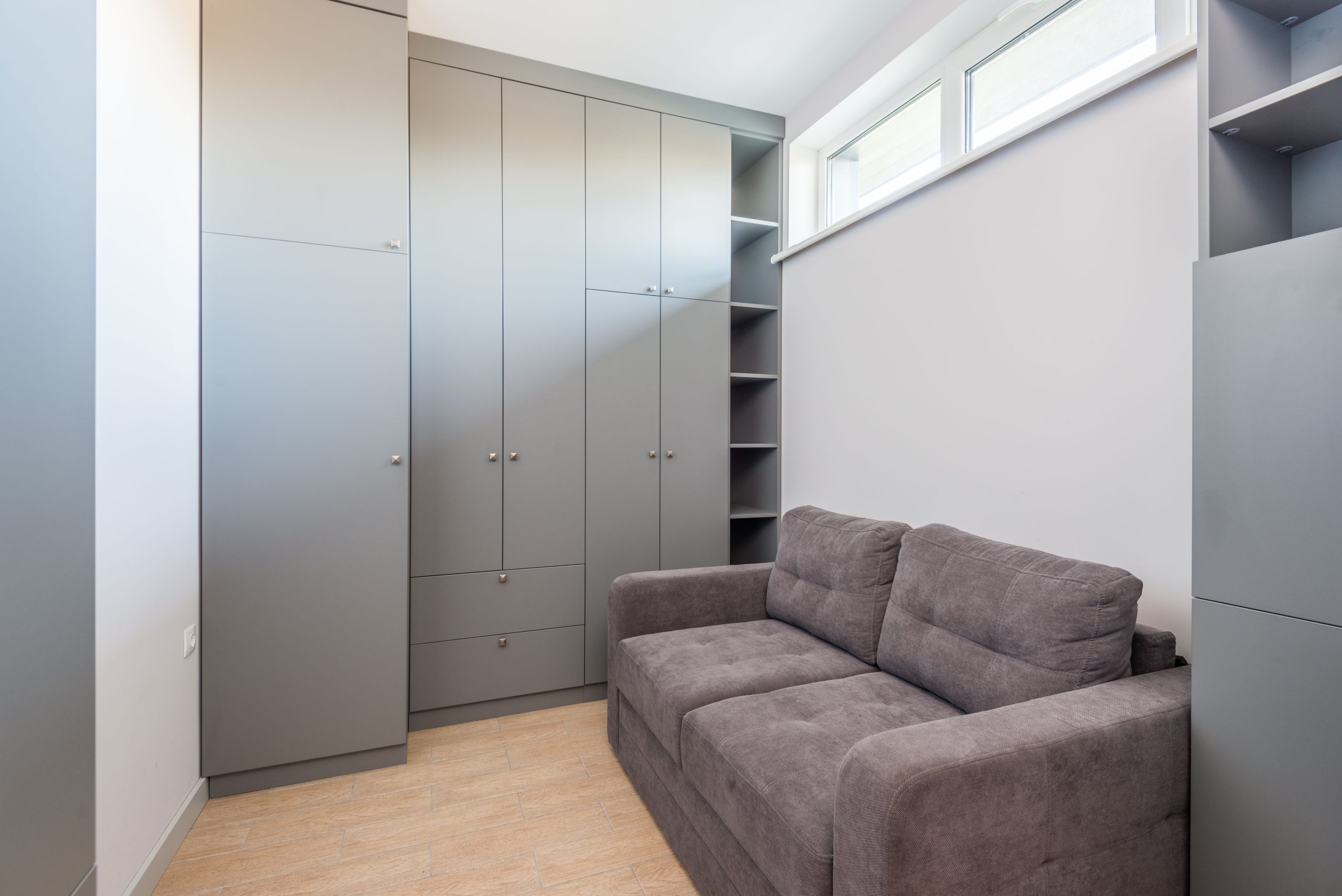 Dressing gris et canapé dans un petit appartement