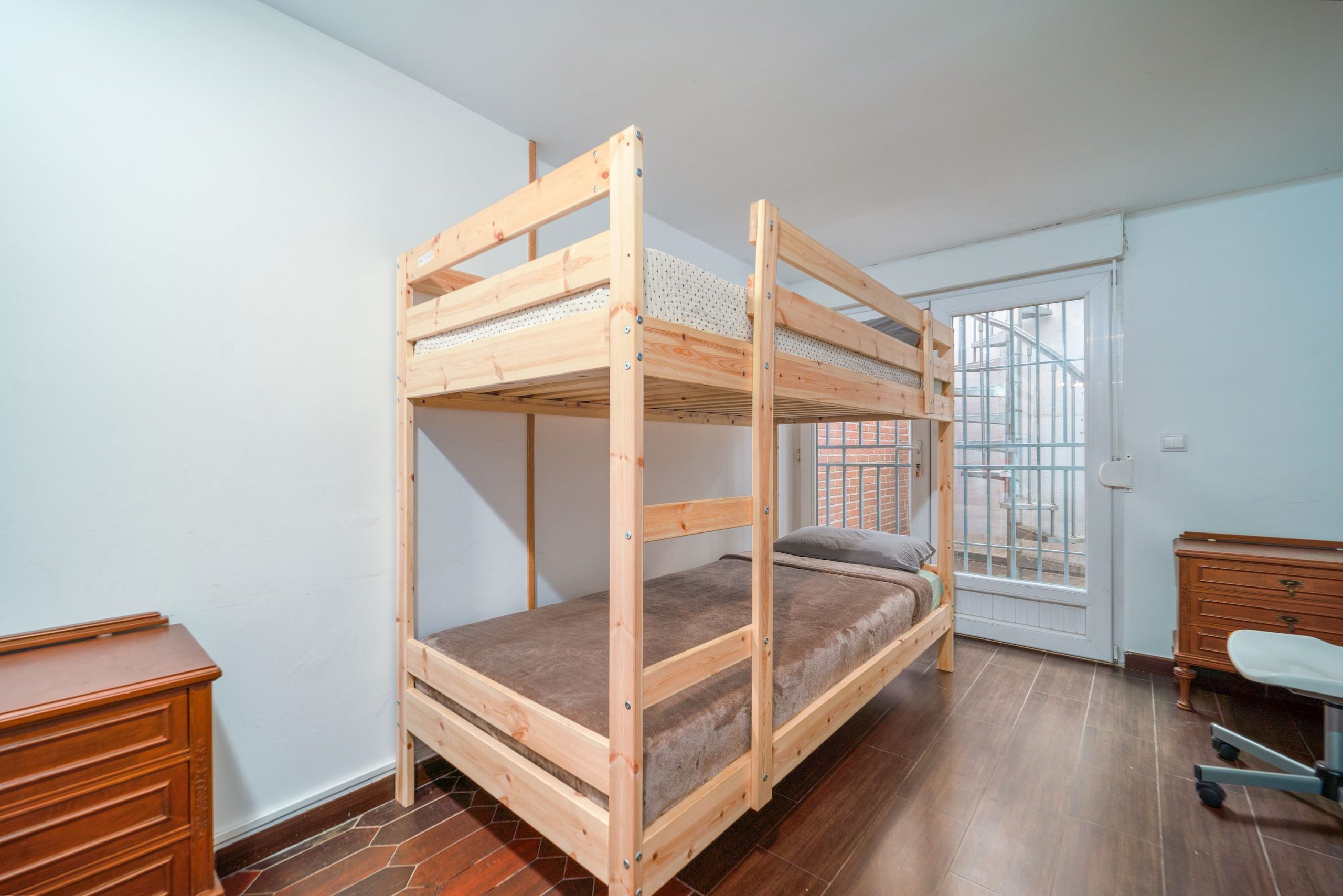 Lit superposé en bois dans une chambre sobre